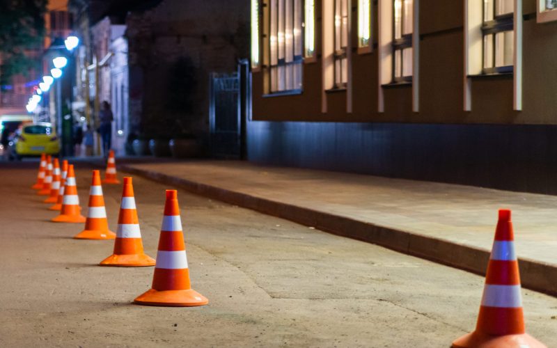 Traffic warning cone in row on street to separate place for parking area.